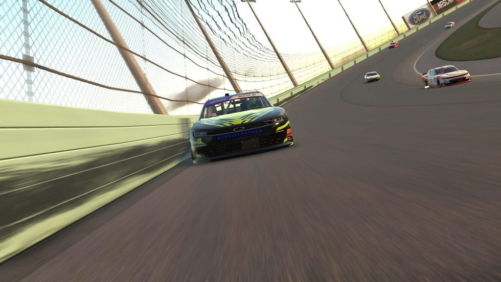 Racing cars negotiate a banked corner in iRacing.