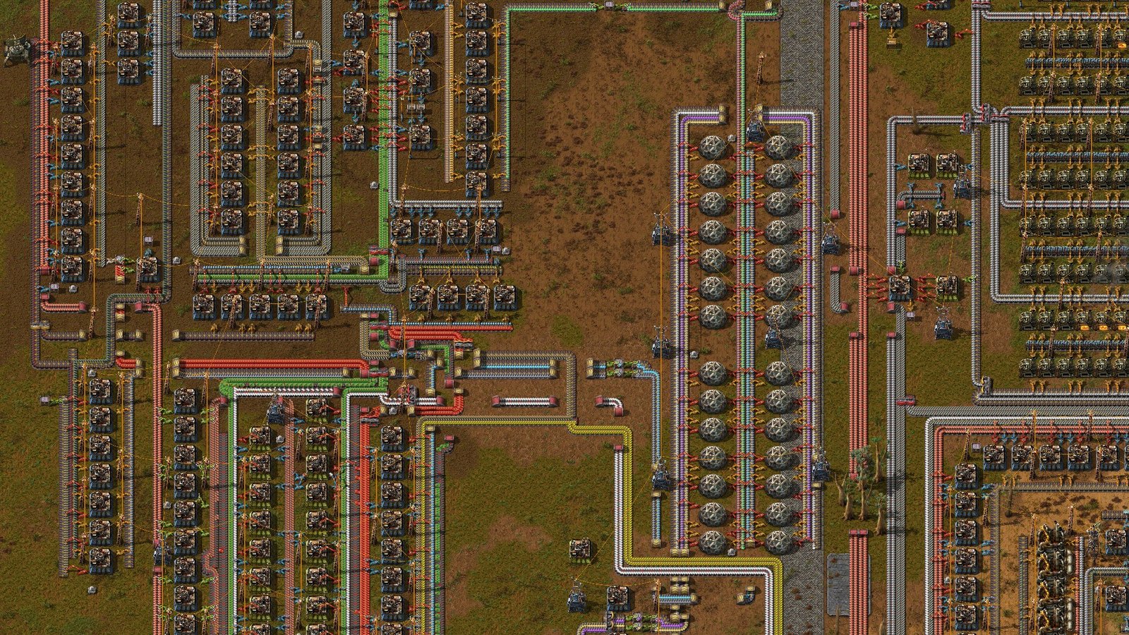 Overhead view of a Factorio factory with conveyor belts, machines, inserters and production lines.